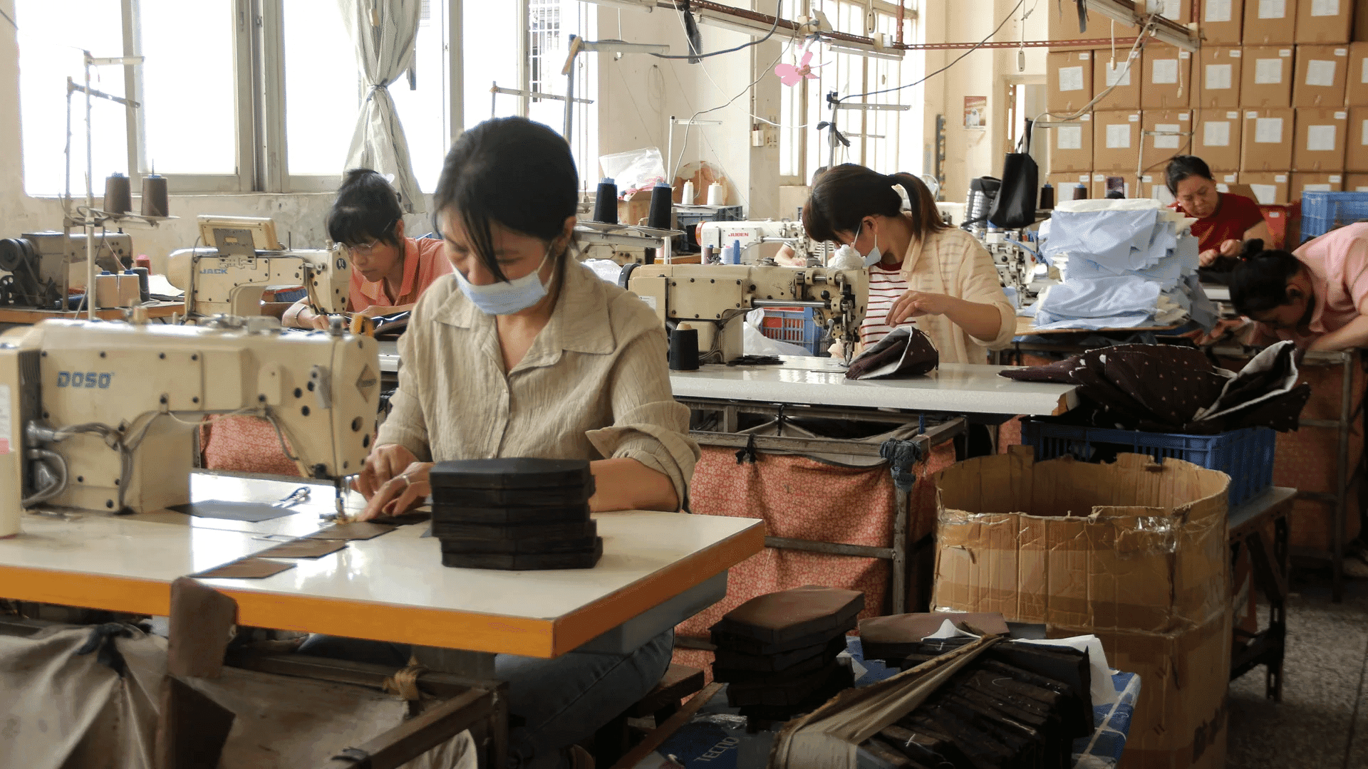Bag makers working at sewing stations in the approved workshop photograph