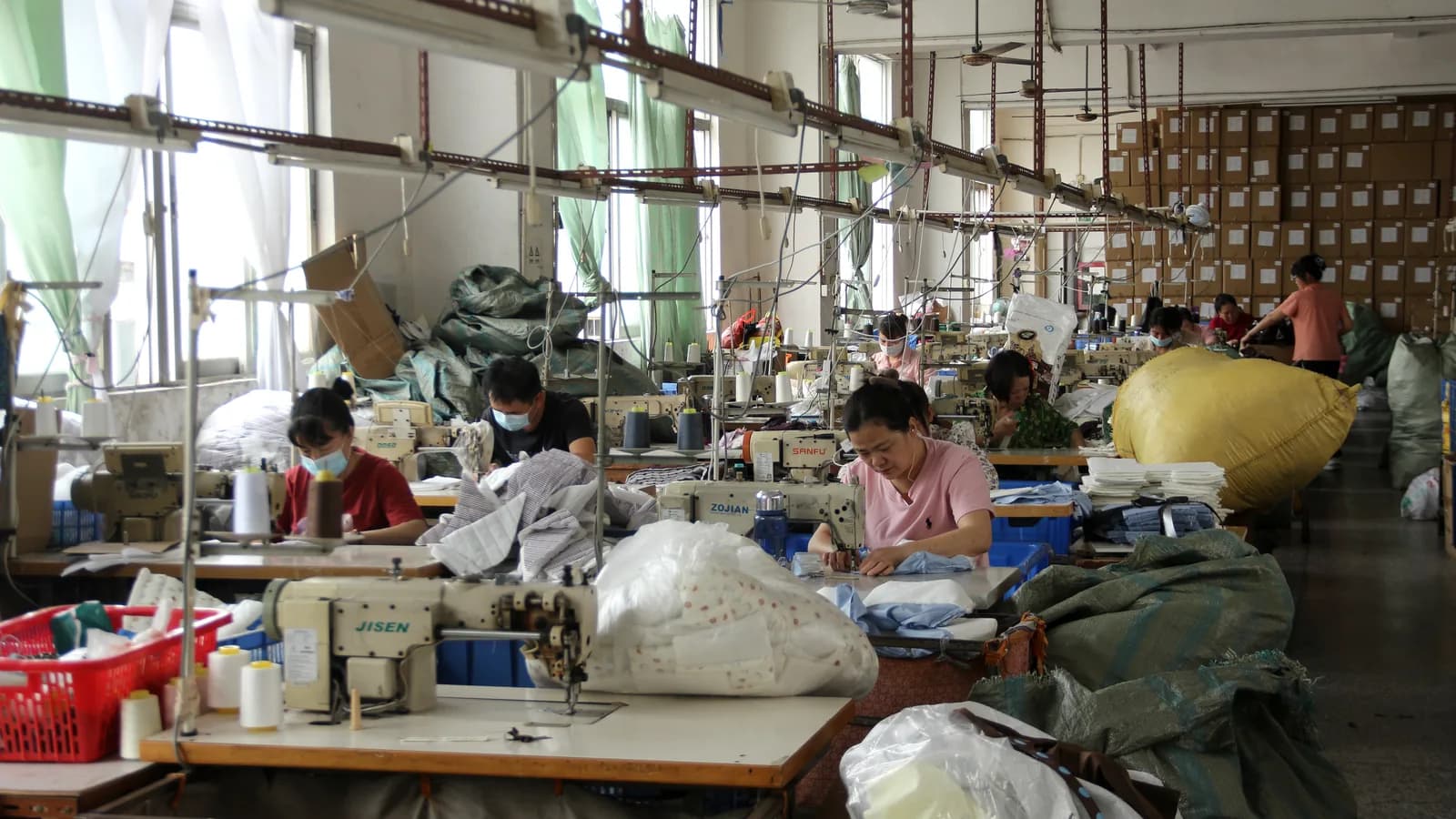 Bag makers working at sewing stations in a production workshop